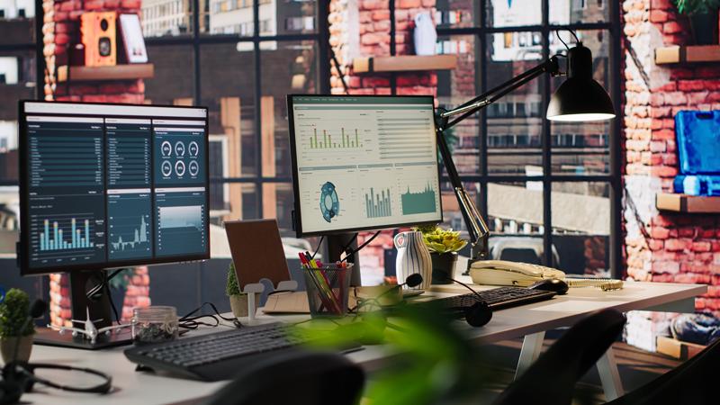computer monitors office desk showing data analytics dashboards 800x450